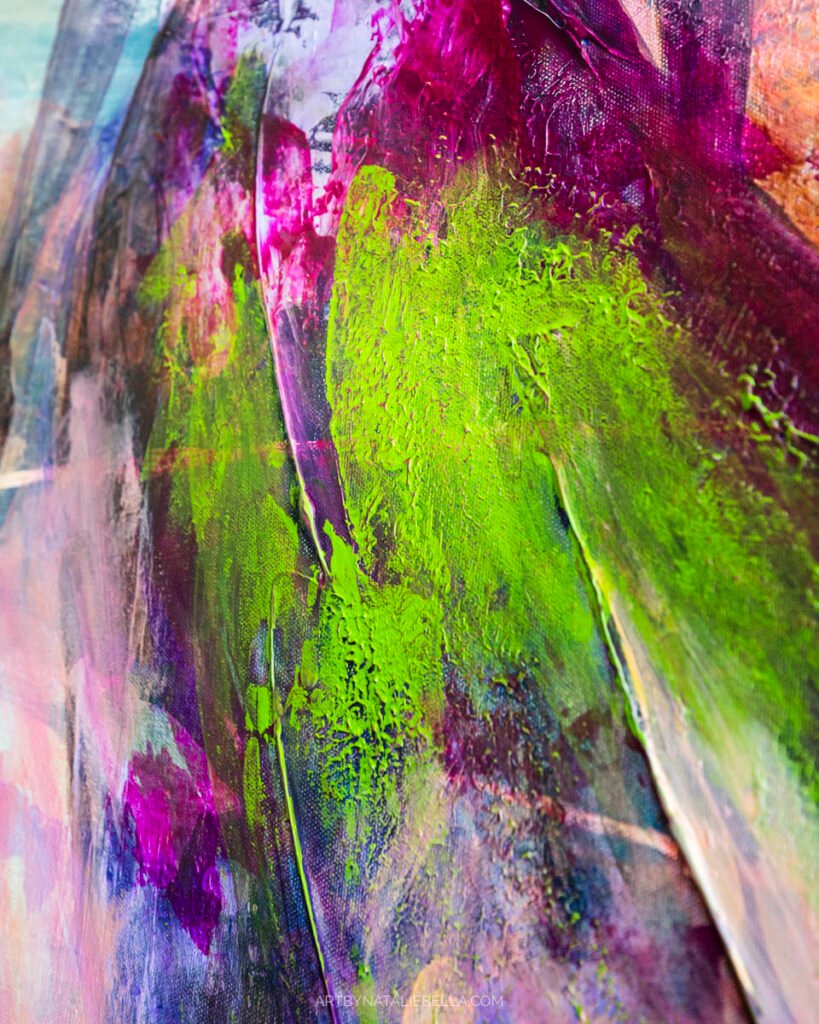 Close-up of vibrant green and purple paint strokes on canvas showing mixed media painting technique in artist studio