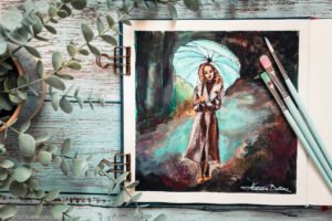 Gouache painting study of woman with umbrella displayed in open watercolor sketchbook with paintbrushes and eucalyptus on rustic wooden background, artist studio setup