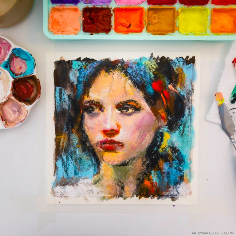 Studio flat lay showing the gouache painting 'Unguarded' - an 8x8 inch portrait of a woman with expressive eyes and red lips, painted in vibrant blues, oranges, and warm skin tones on watercolor paper. The painting is surrounded by art supplies including a well-used watercolor palette with colorful paint wells, a palette knife, and small containers of mixed paint, all arranged on a white surface.