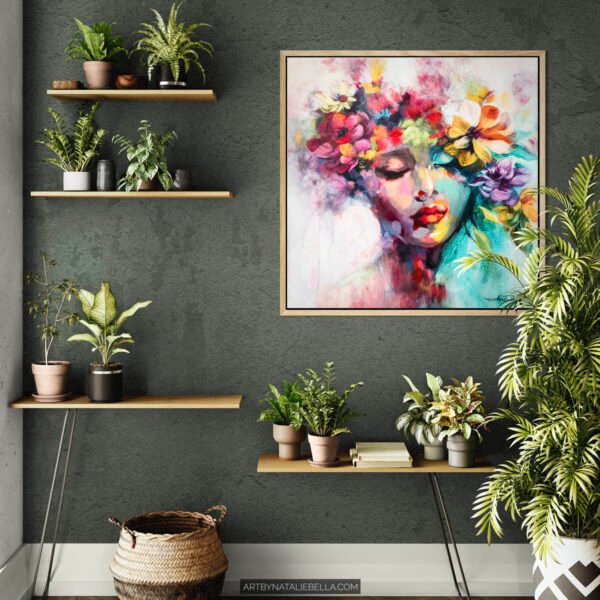 Contemporary home interior styling featuring Garden of Dreams, a 24x24 inch original oil painting by Natalie Bella. Vibrant floral portrait with pink, orange and turquoise tones displayed on dark gray wall with natural wood floating shelves and indoor plants. Available feminine artwork for modern living spaces.