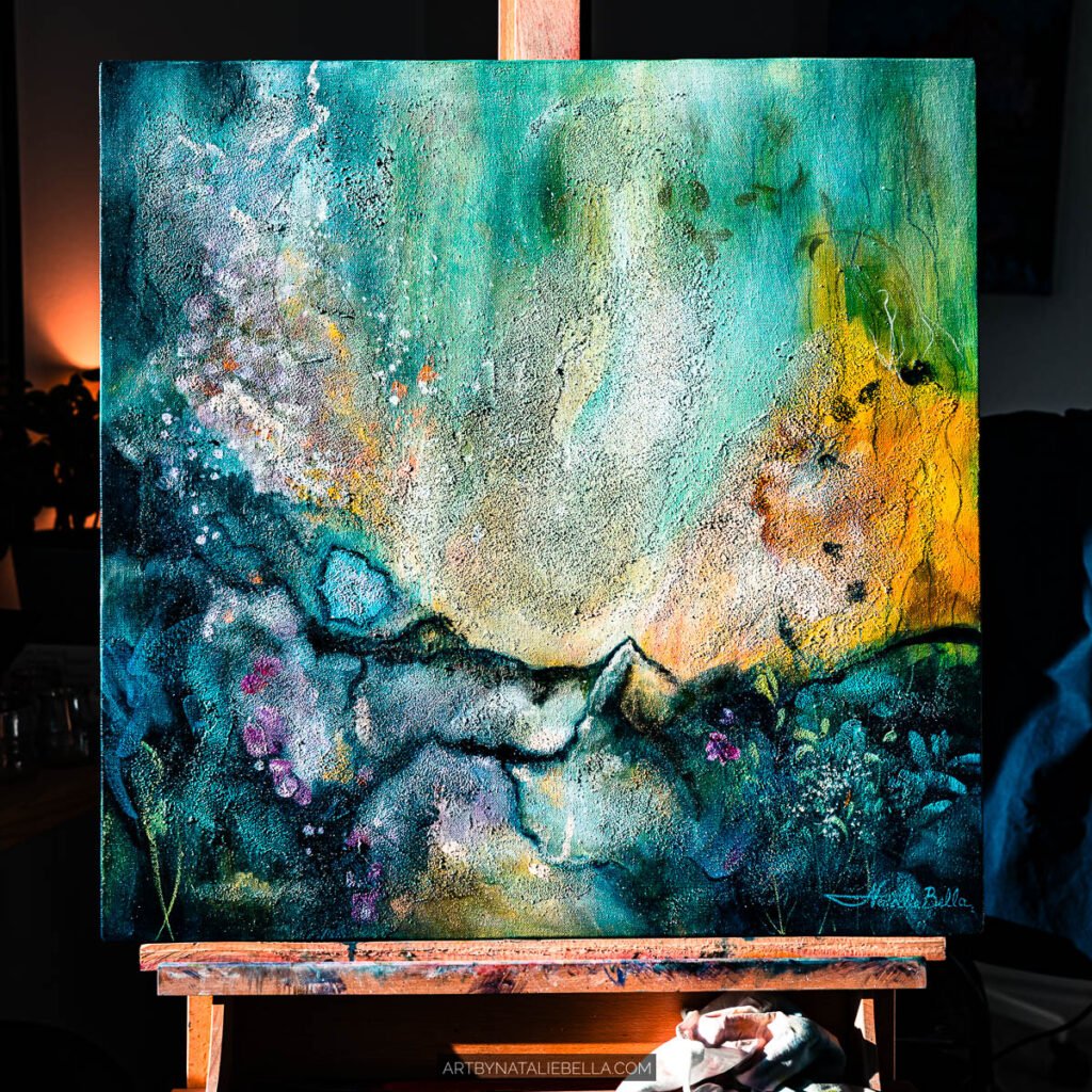 Original 24x24 teal abstract painting Awakening displayed on an easel in natural studio light, showing the full composition in oil and mixed media by Las Vegas artist Natalie Bella